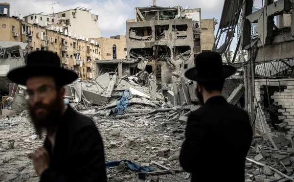 Ultra-Orthodox Zionist settlers inspect the damage at the site of an Iranian missile strike in Bnei Brak, east of Tel Aviv, on June 16, 2025